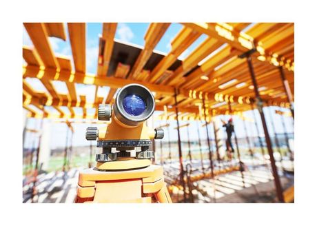 laser surveying equipment set up under open floor framing joists