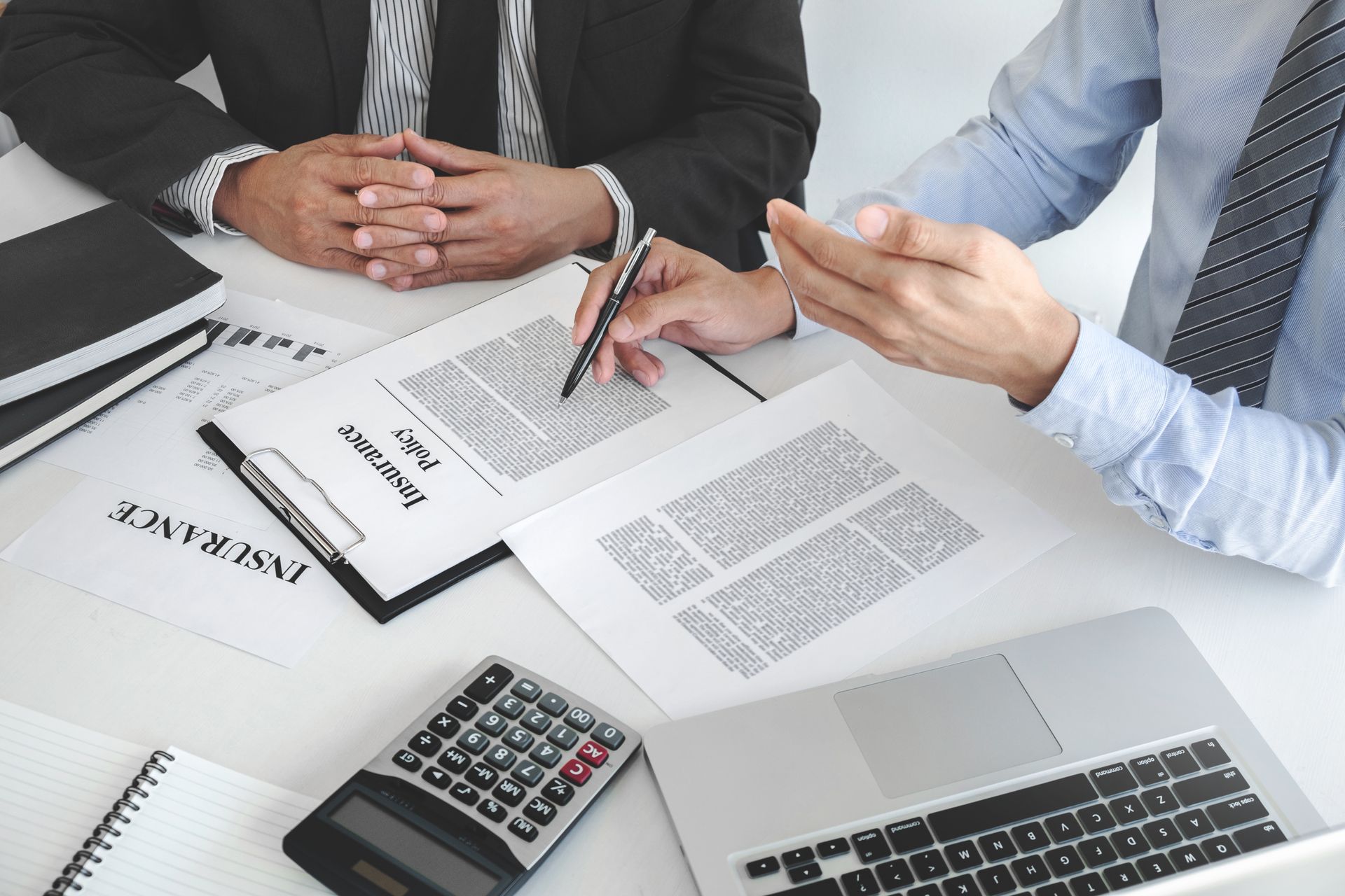 Insurance agent reviewing policy documents with client. Insurance agent reviewing policy documents with client.