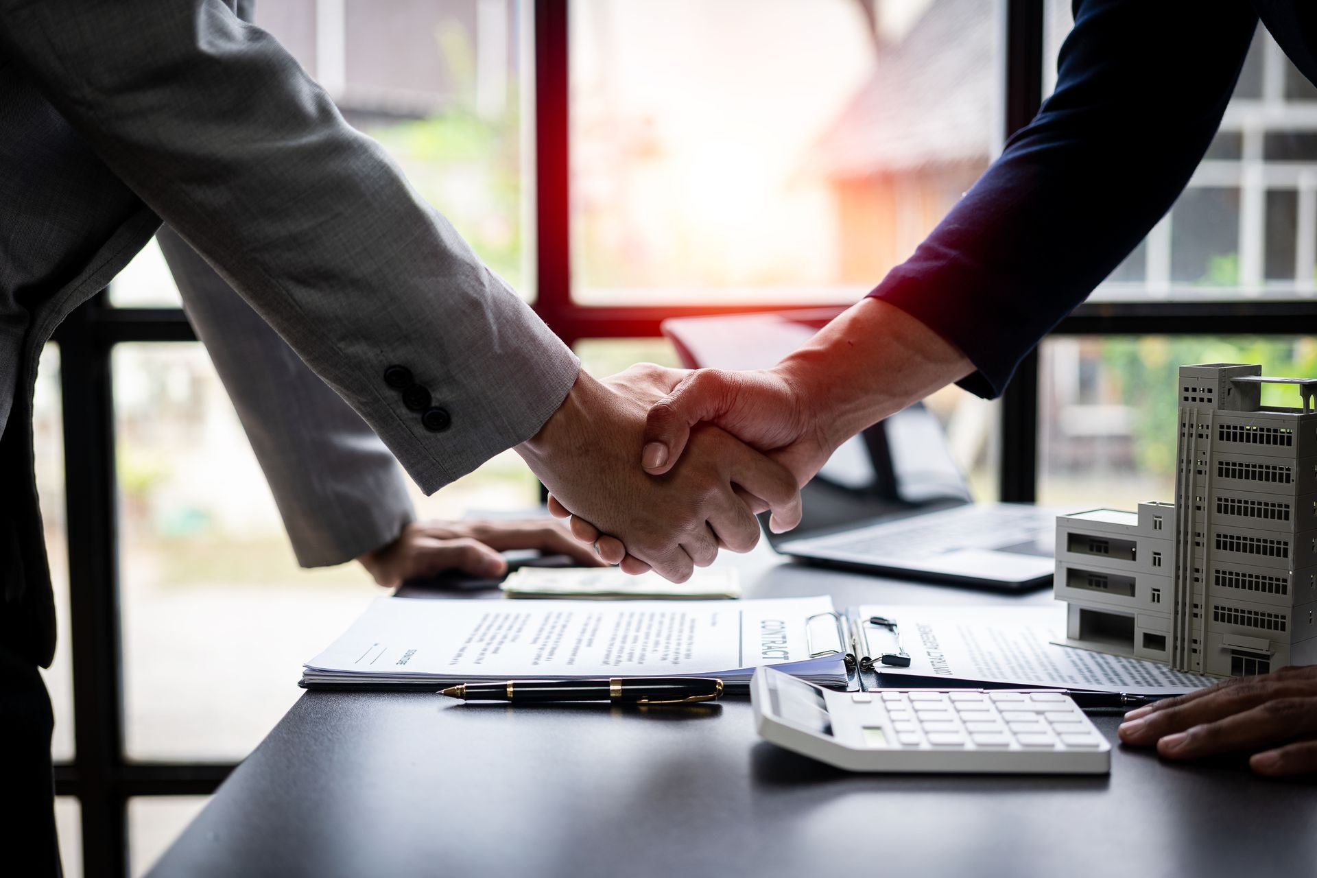 Handshake over insurance documents on office desk. Handshake over insurance documents on office desk.