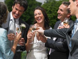 Guests toasting with champagne at a joyful outdoor wedding reception