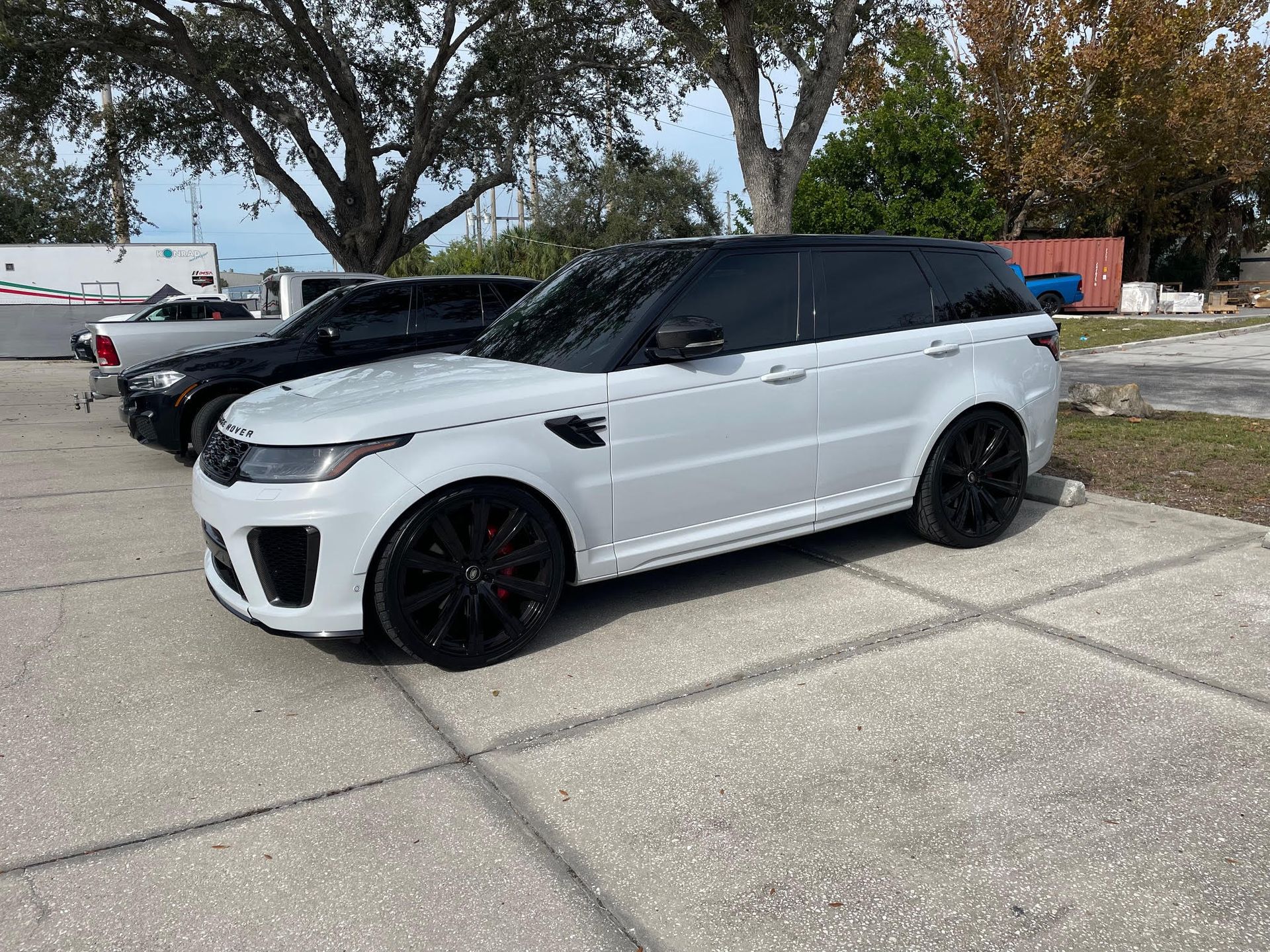 White Range Rover Parked Next to SRQ Motorsports Repair Shop