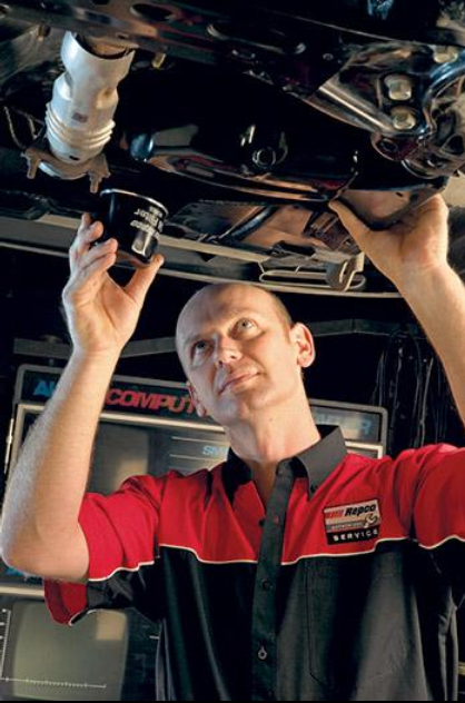 A Mechanic Is Examining The Underside Of A Car In A Garage — All Automotive Services In Bundaberg East, QLD