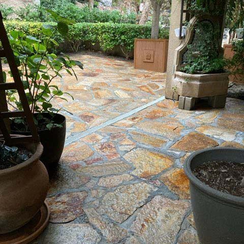Stone garden patio with potted plants and greenery