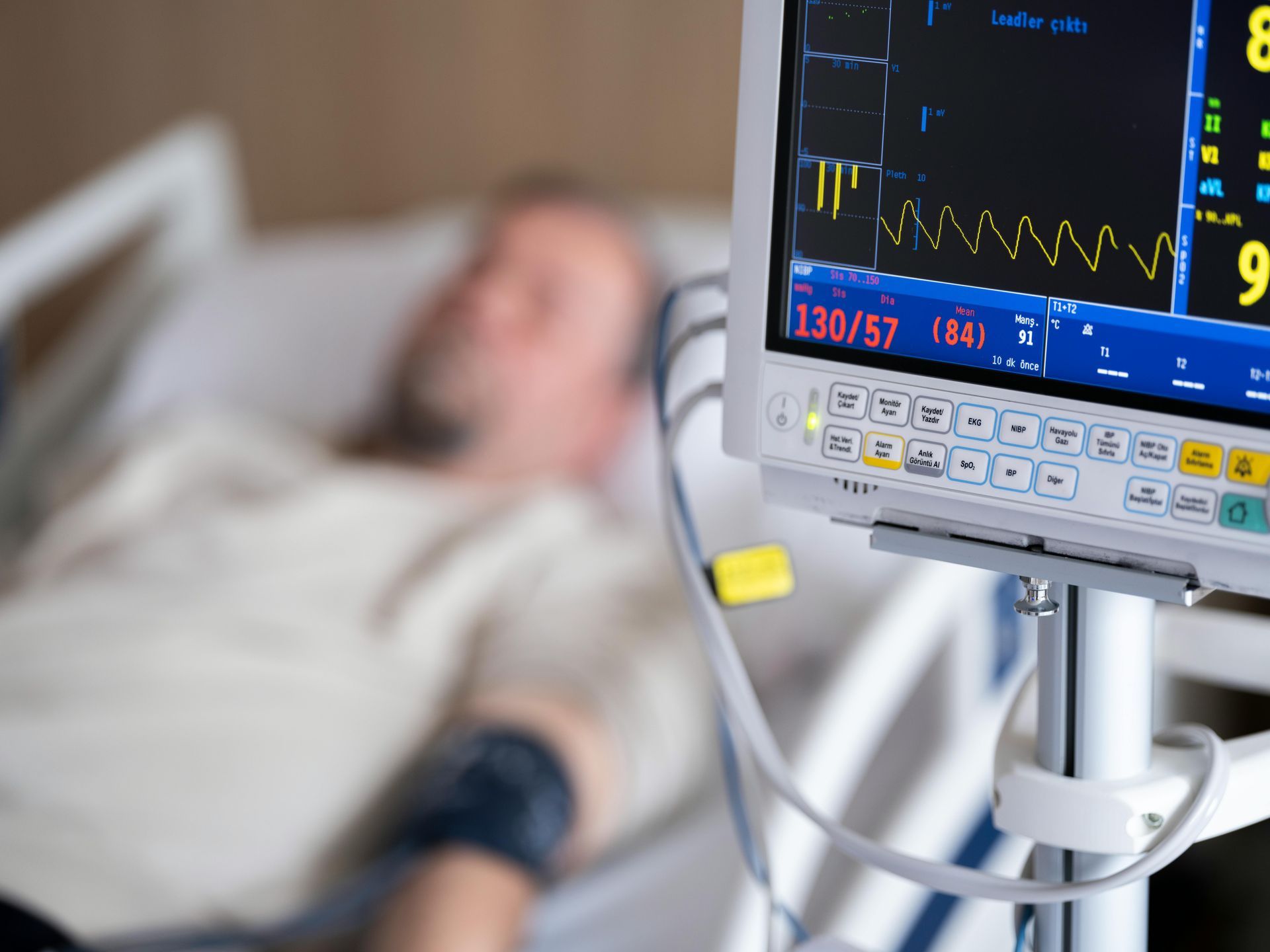 A man wearing a mask is holding his chest in pain.