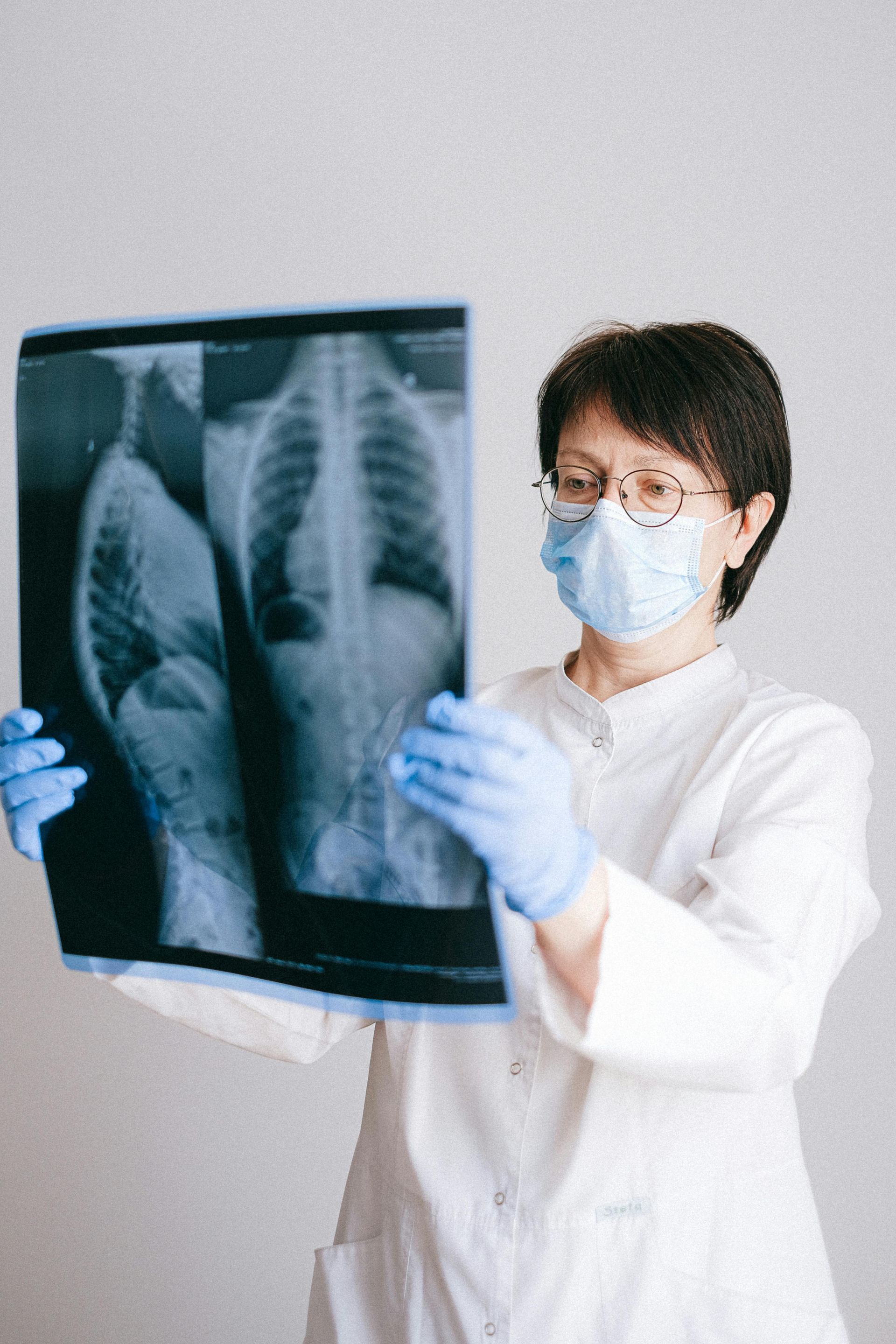 A woman is using a nasal spray in her mouth.