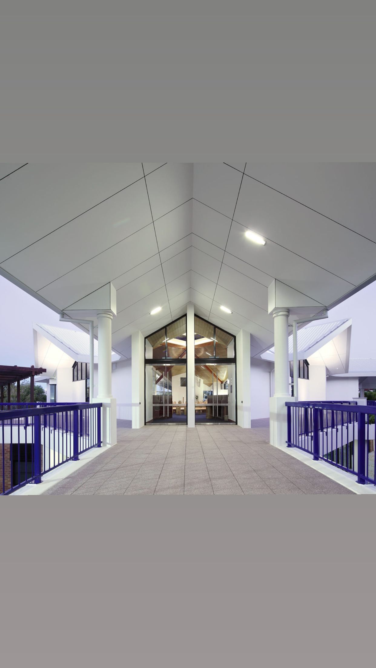 A Large Building With a Covered Walkway Leading to It — JIC Projects Pty Ltd in Runaway Bay, QLD