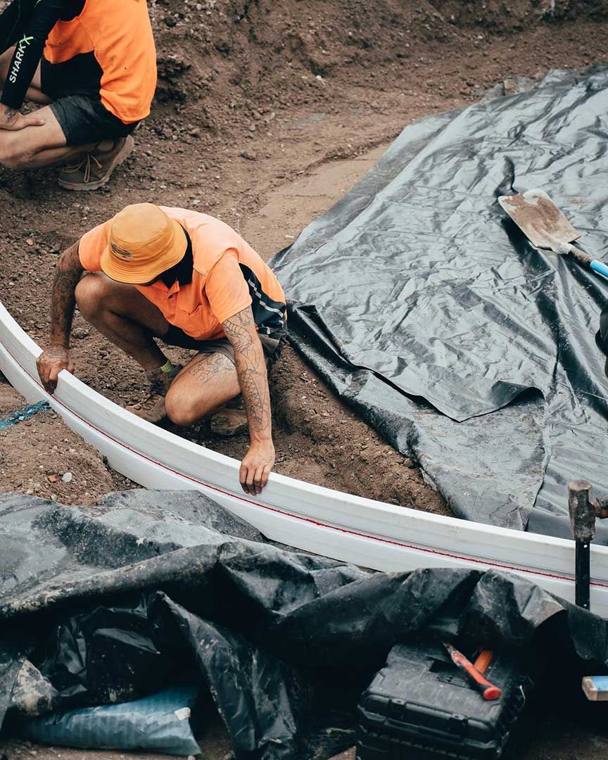 A Man is Measuring a White Pipe in the Dirt — JIC Projects Pty Ltd in Runaway Bay, QLD