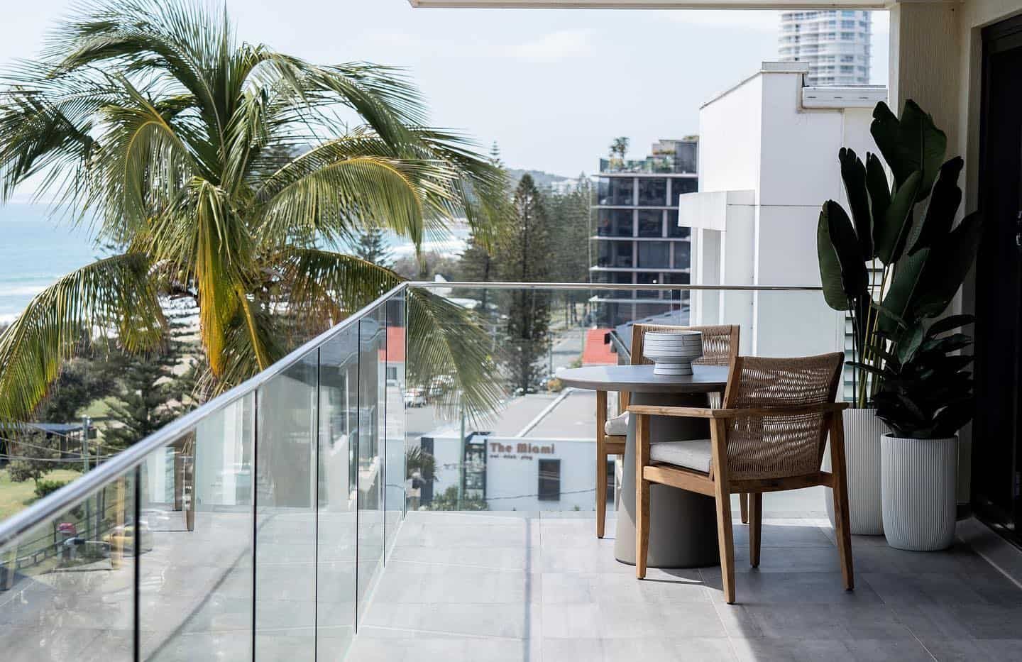A Balcony With a Table and Chairs and a View of the Ocean — JIC Projects Pty Ltd in Runaway Bay, QLD