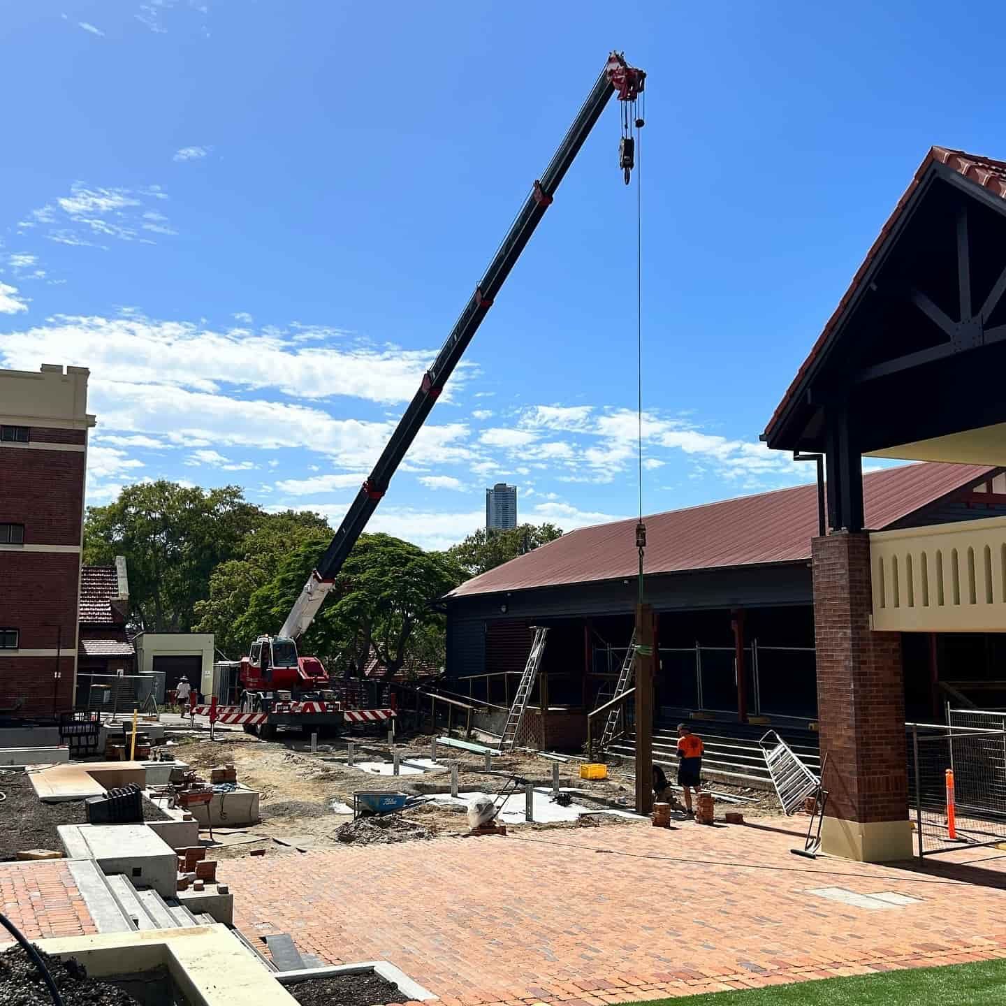 A Large Crane is Being Used to Lift a Brick Building — JIC Projects Pty Ltd in Runaway Bay, QLD