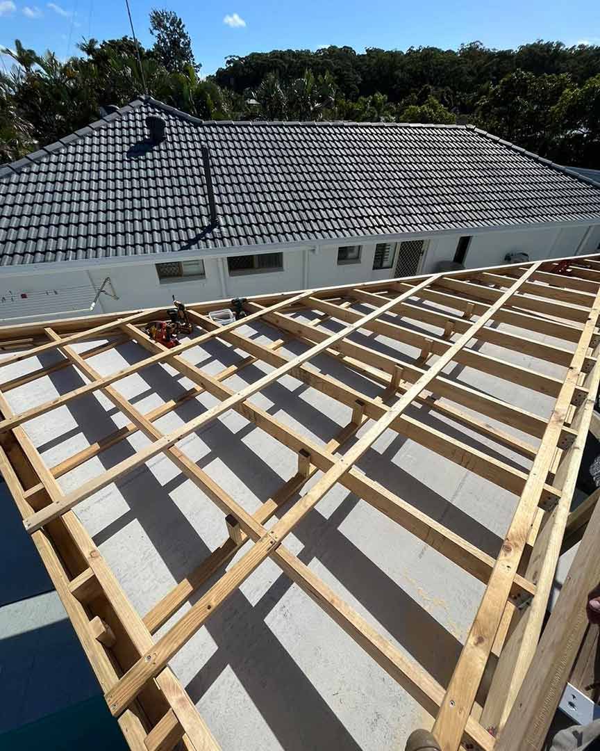 The Roof of a House is Being Built With Wooden Beams — JIC Projects Pty Ltd in Runaway Bay, QLD