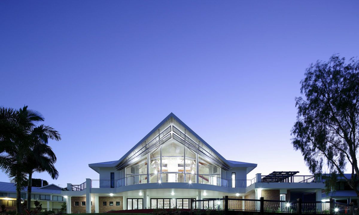 Aspacious House at Twilight, Featuring Large Glass Windows and a Triangular Roof — JIC Projects Pty Ltd in Runaway Bay, QLD