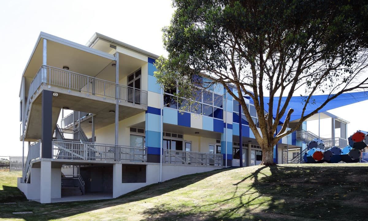 A Two-story Building With Blue and White Facades, Surrounded by Greenery — JIC Projects Pty Ltd in Runaway Bay, QLD