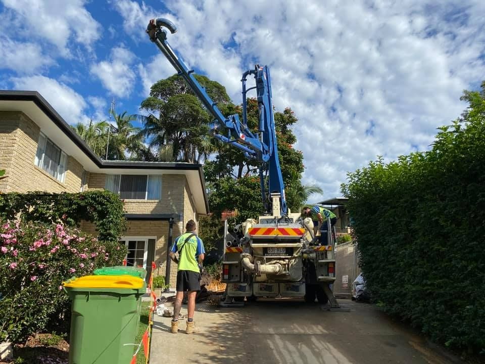 A Man is Standing in Front of a Concrete Pump Truck — JIC Projects Pty Ltd in Runaway Bay, QLD