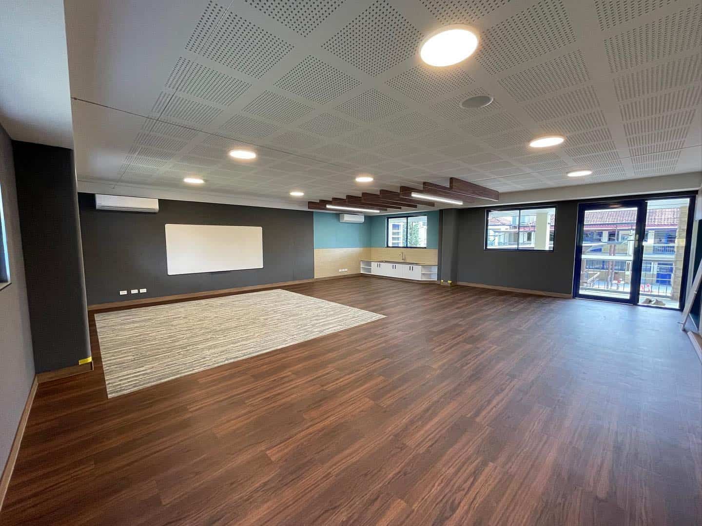 A Large Room With Wooden Floors and a Whiteboard on the Wall — JIC Projects Pty Ltd in Runaway Bay, QLD