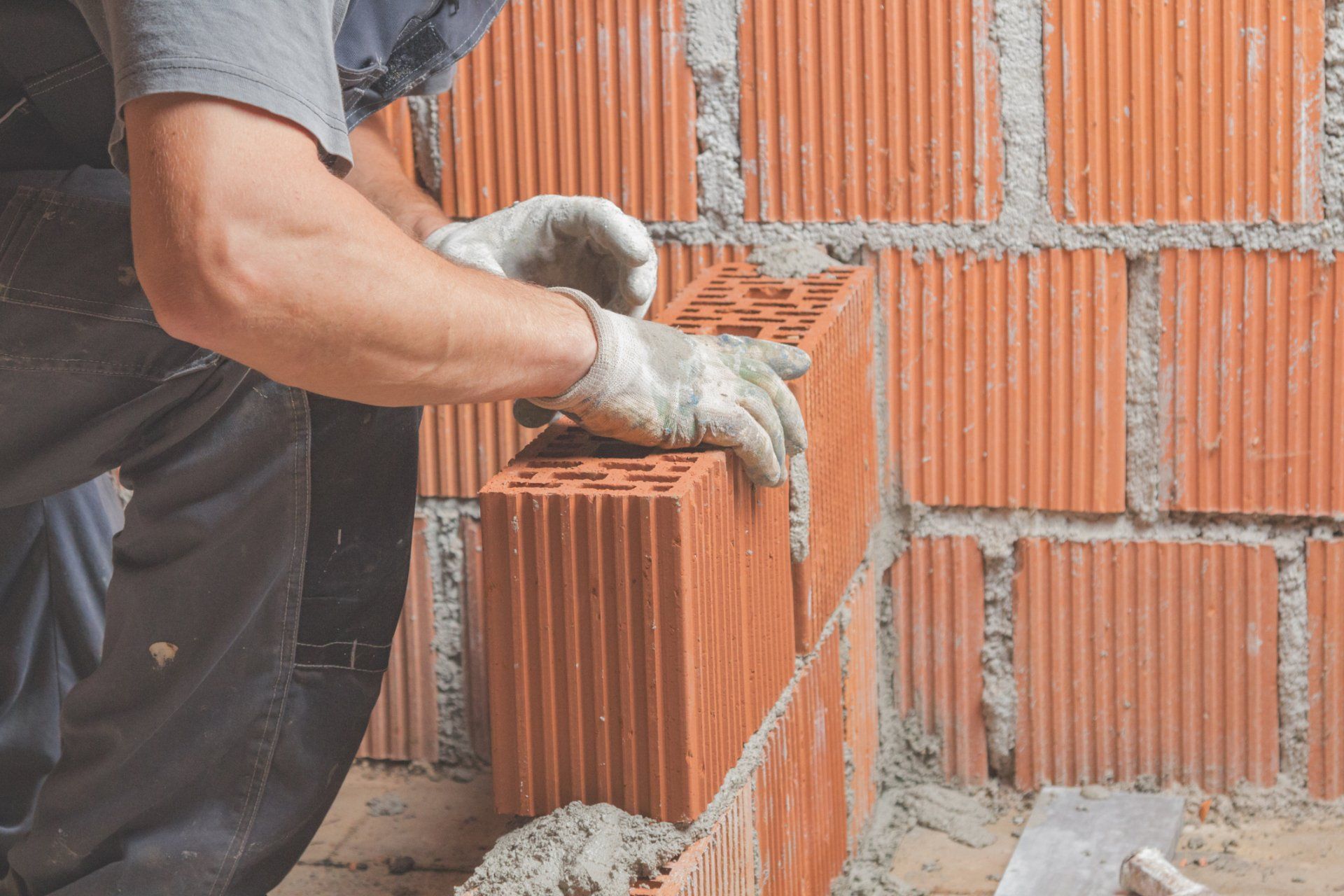 Construction Worker Bricklaying The Wall Indoors - Allen, TX - Alpha Foundation Repair LLC Construction Worker Bricklaying The Wall Indoors - Allen, TX - Alpha Foundation Repair LLC
