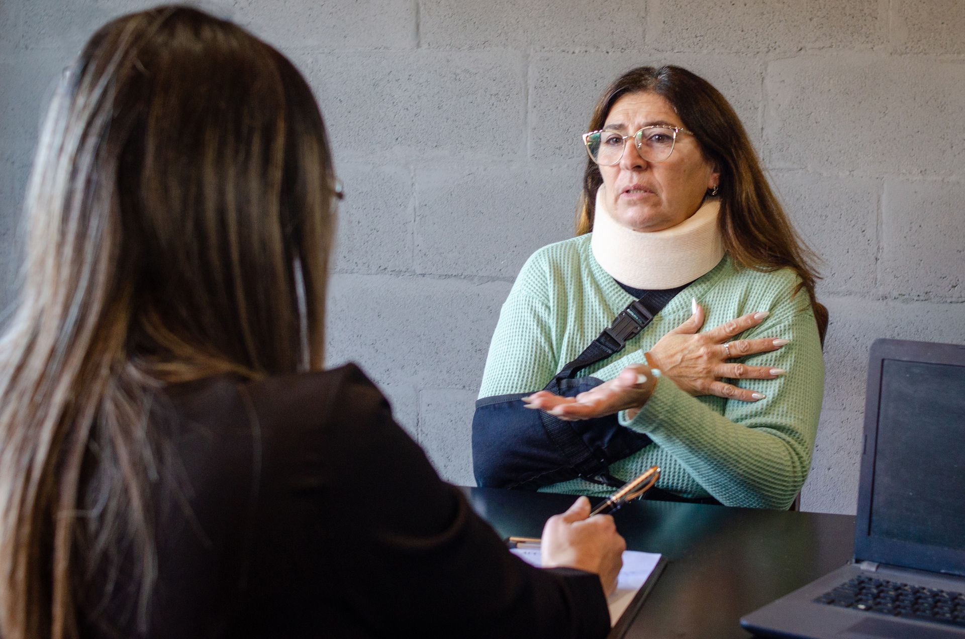 Personal injury client wearing a neck brace during a legal consultation.