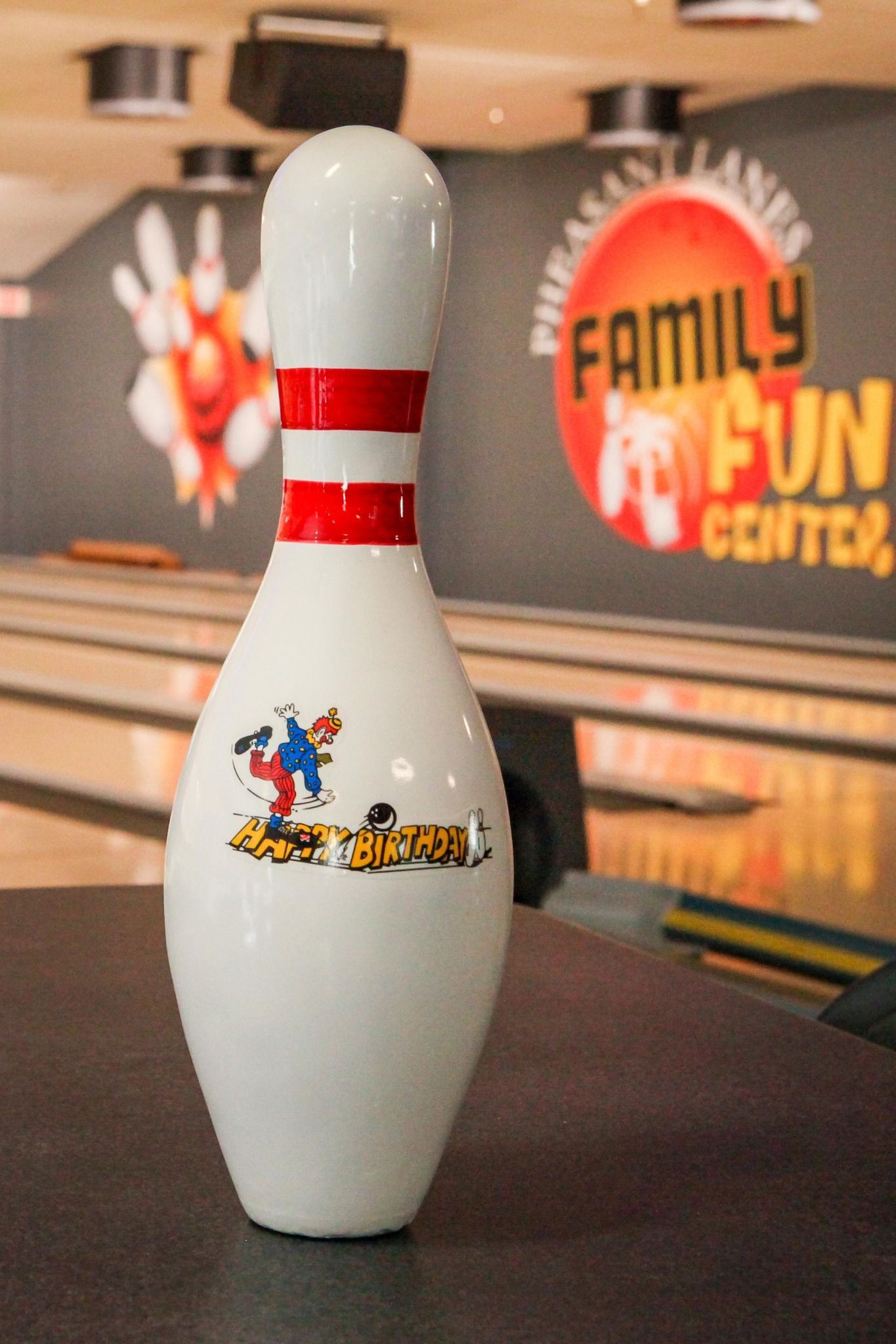 White bowling pin on a lane with a Family Fun Center sign in the background