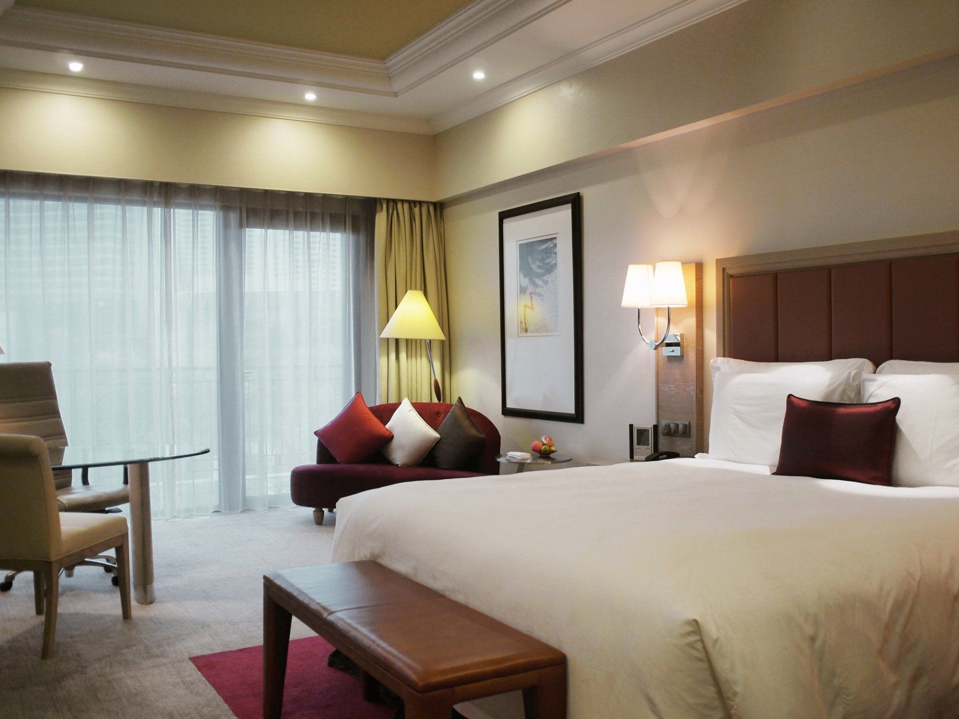 A hotel room with a large bed , couch , desk and chairs.