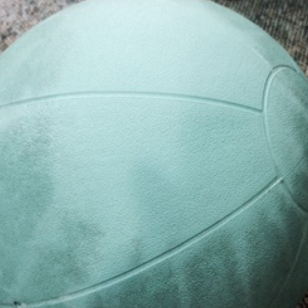 A close up of a green volleyball on a table.