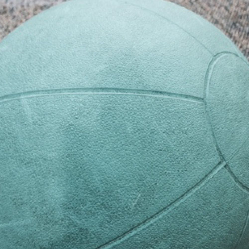 A close up of a green basketball on a table.