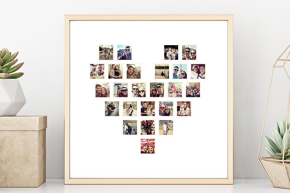 A heart shaped photo collage in a wooden frame is sitting on a shelf next to a couple of plants.