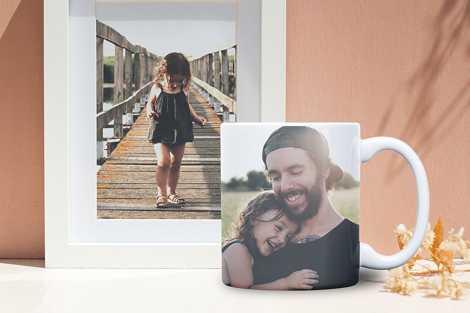 A mug with a picture of a Father and daughter  and a print in the background