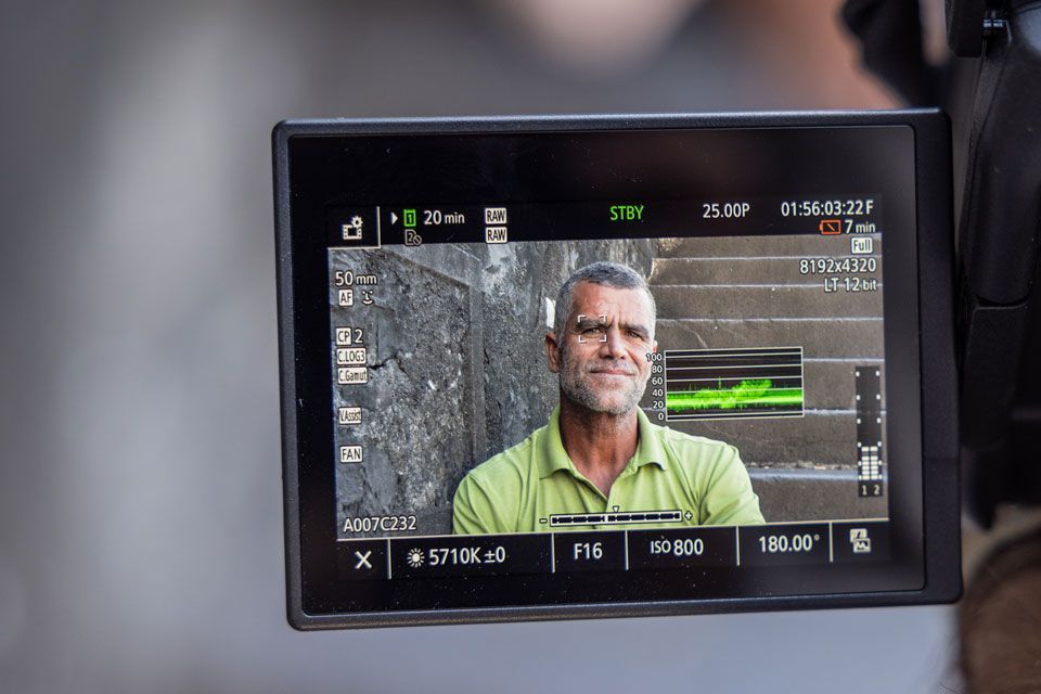 A person with a digital camera taking a video of a man
