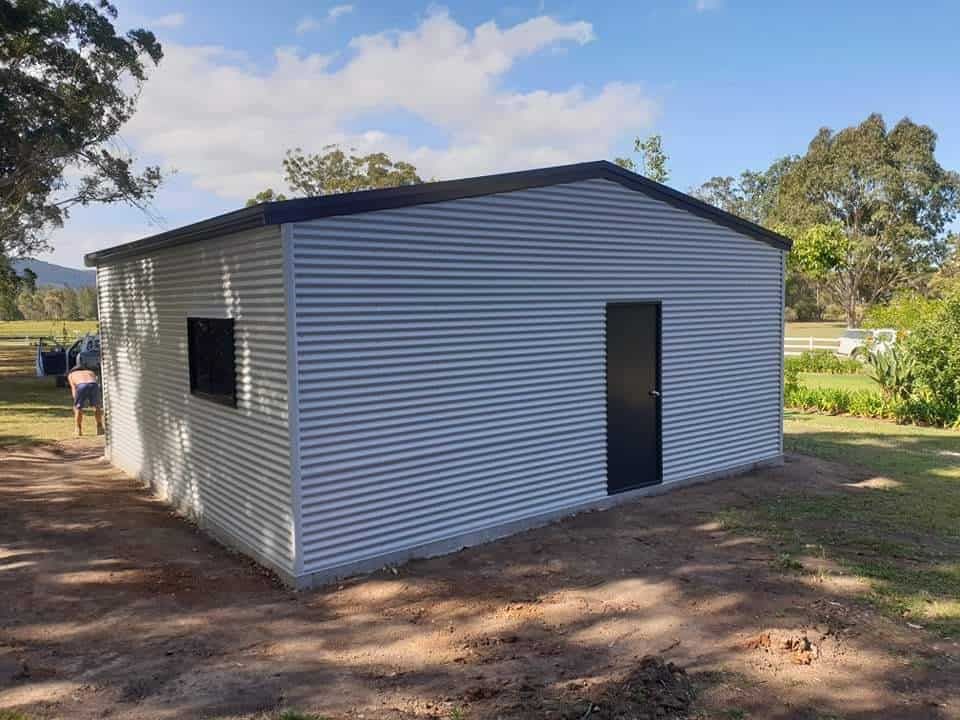A Small White Building With a Black Door — Hastings Valley Sheds in Laurieton, NSW