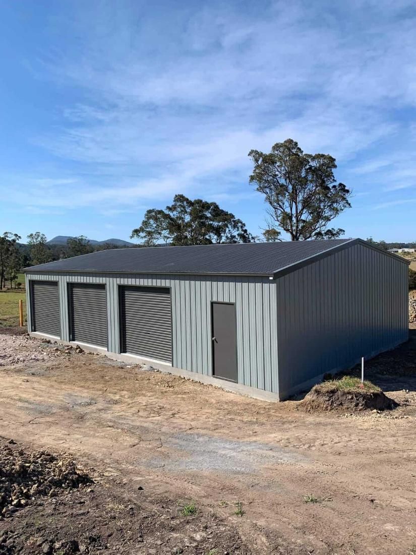 A Large Metal Building With a Black Roof — Hastings Valley Sheds in Wauchope, NSW