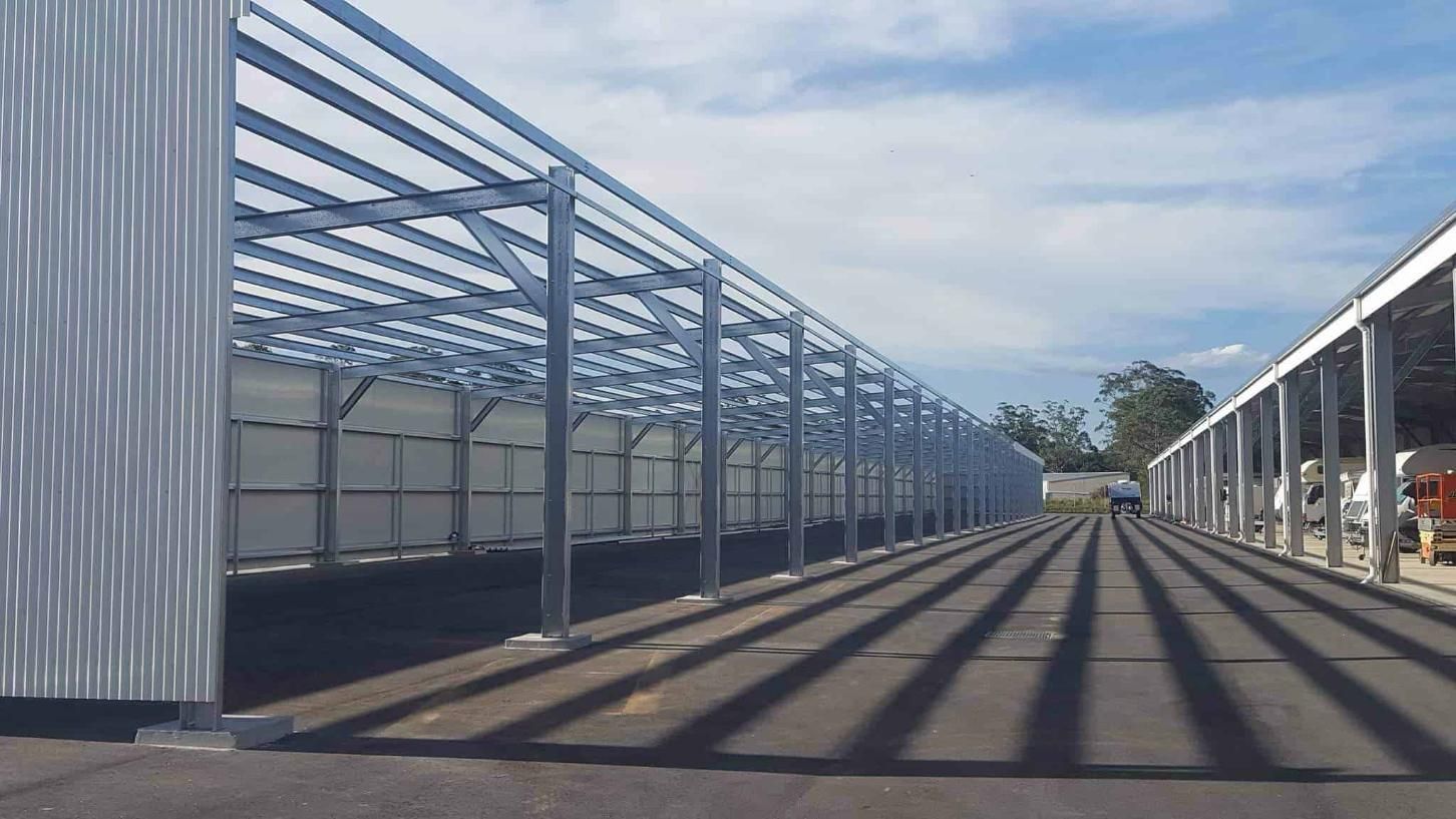A Large Metal Structure is Being Built on the Side of a Road — Hastings Valley Sheds in Wauchope, NSW