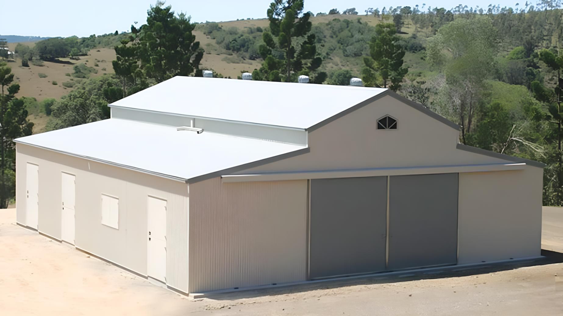 A Large Building With a White Roof and Gray Doors — Hastings Valley Sheds in Wauchope, NSW