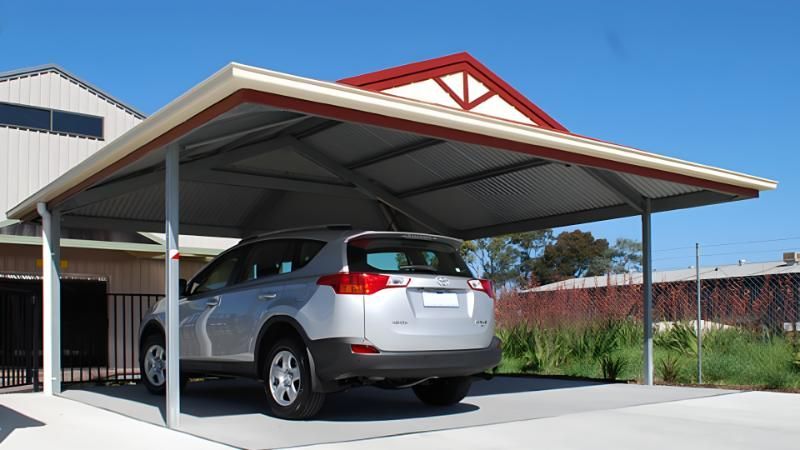 A Car is Parked Under a Carport With a Red Roof — Hastings Valley Sheds in Wauchope, NSW