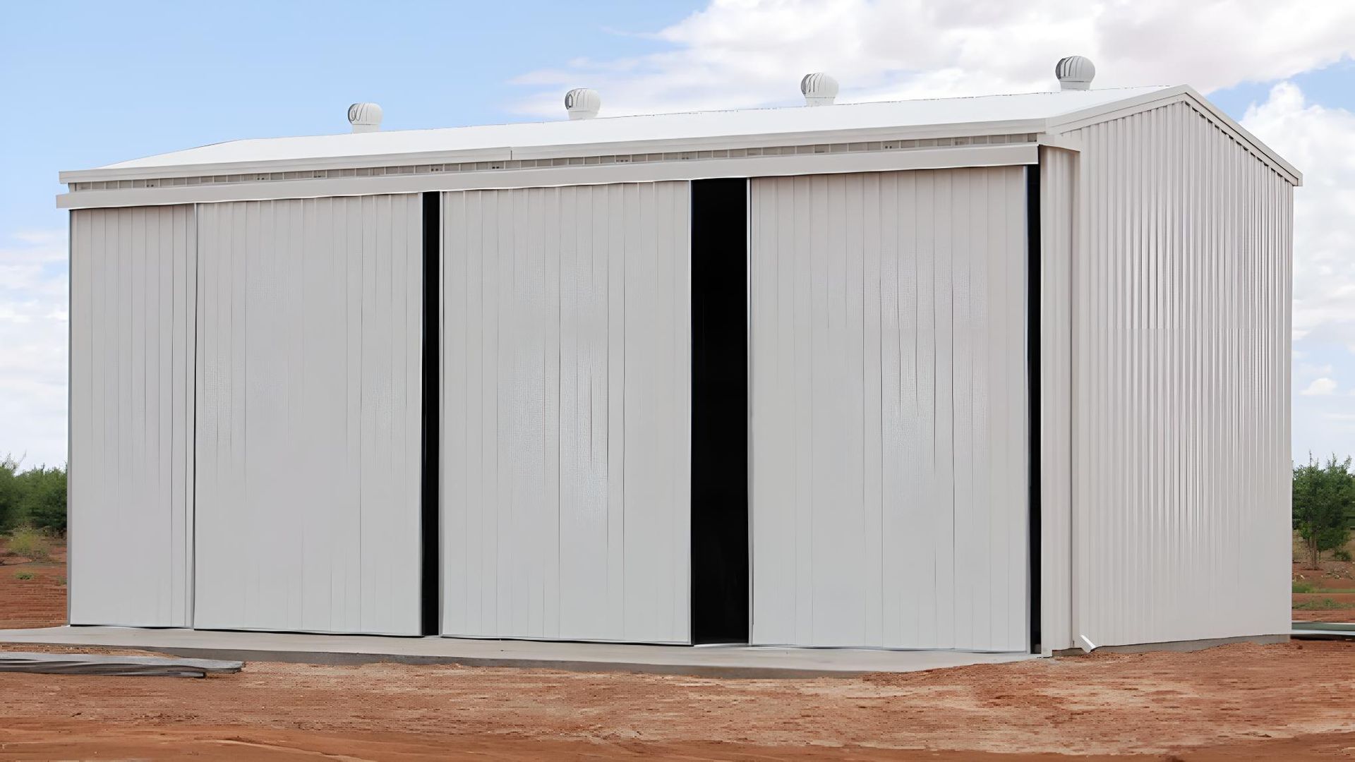 A Large White Building With Sliding Doors — Hastings Valley Sheds in Wauchope, NSW