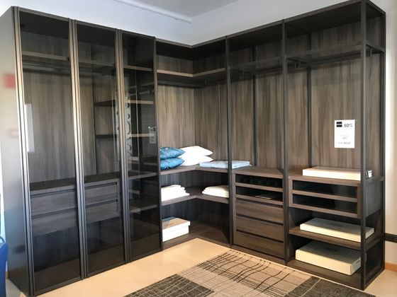 Legno scuro, cabina armadio con ripiani, cassetti e spazio per appendere gli abiti. Vuoto.