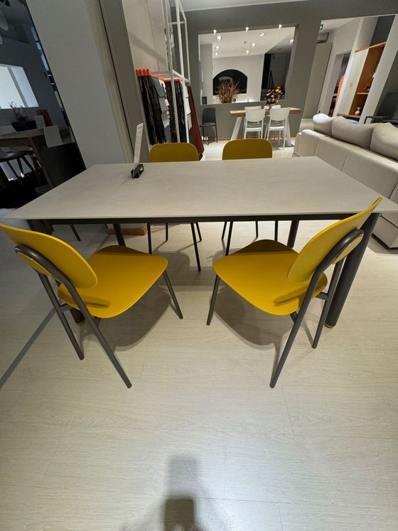 Sedie gialle attorno a un tavolo bianco in uno showroom.