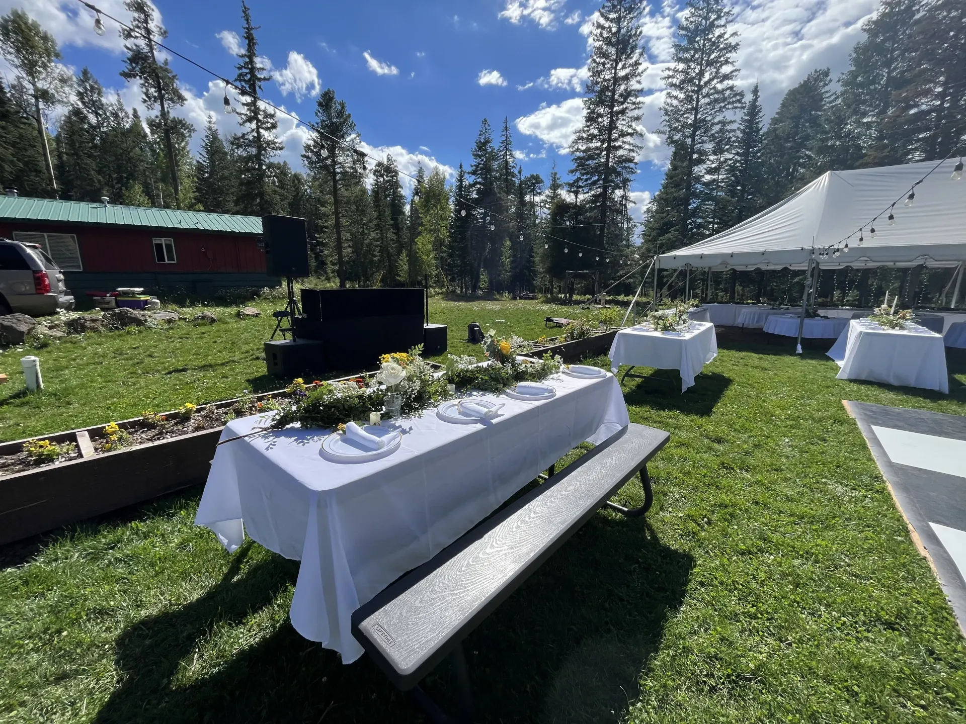 A table and bench are set up in a grassy field.