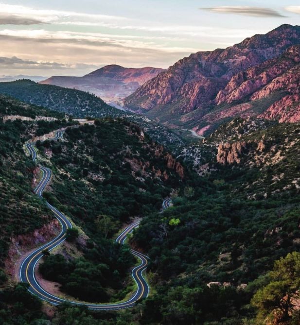 An aerial view of a winding road in the mountains.