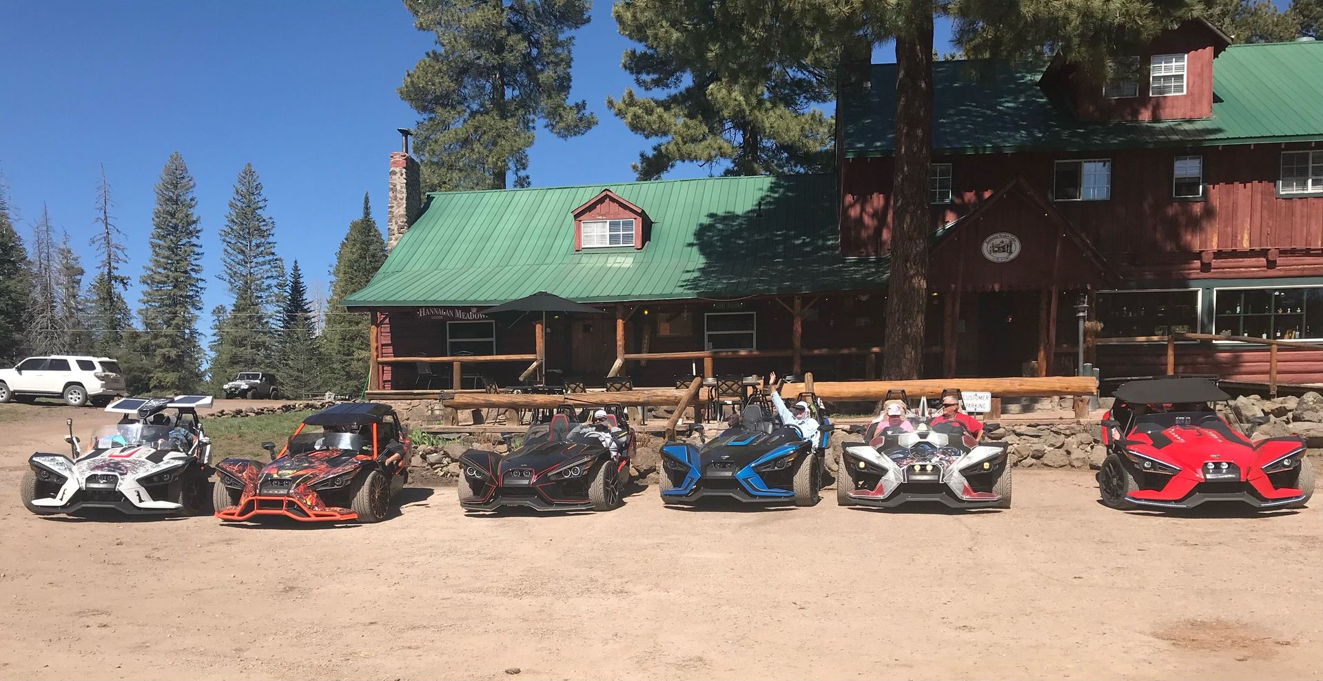 A row of slingshot motorcycles are parked in front of a house.