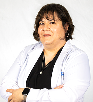 A woman in a white lab coat and black scrub is standing with her arms crossed.