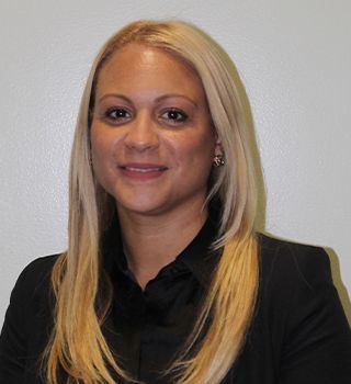 A woman with blonde hair is wearing a black shirt and a black jacket.