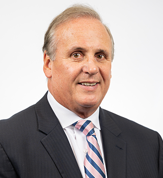 A man in a suit and tie is smiling for the camera.