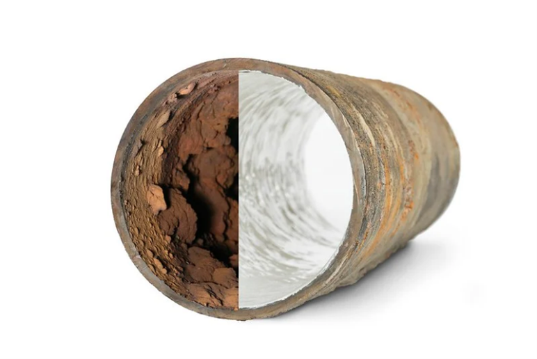 A close up of a rusty pipe and a clean pipe on a white background.