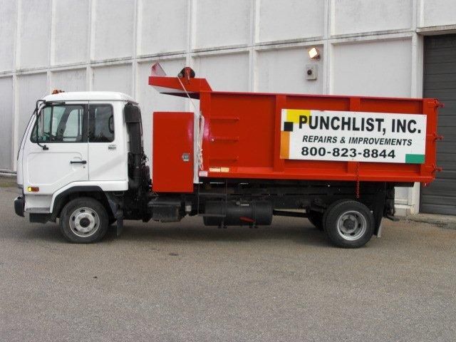 A punchlist truck is parked in front of a building