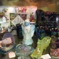 A collection of vintage glass items, including an angel figurine, a yellow glass shoe, and small decorative bowls.
