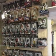 A retail store wall display featuring numerous boxed baseball player action figures arranged in rows.