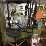A black stationary exercise bike with an orange housing in a room filled with glass display cabinets of collectibles.