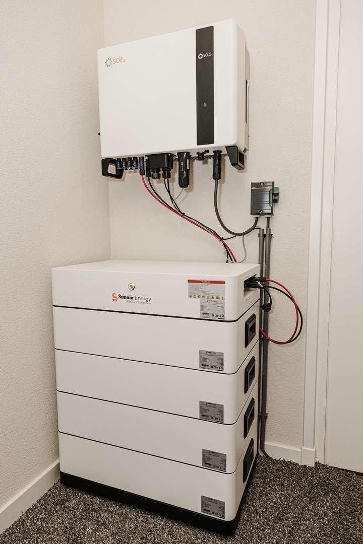 Een man in pak houdt een gloeiende batterij in zijn handen.