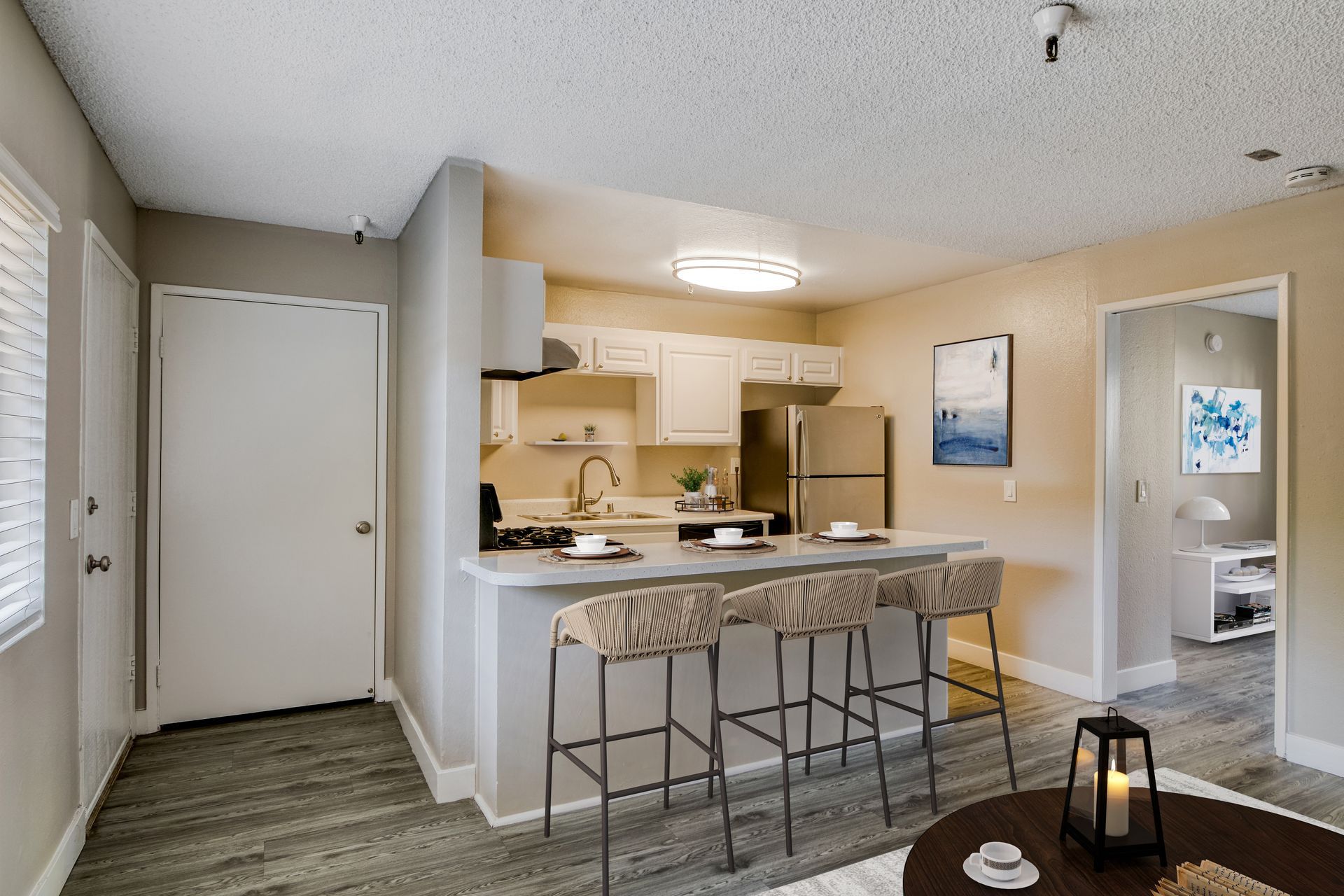 A living room with a kitchen , dining room , and refrigerator.