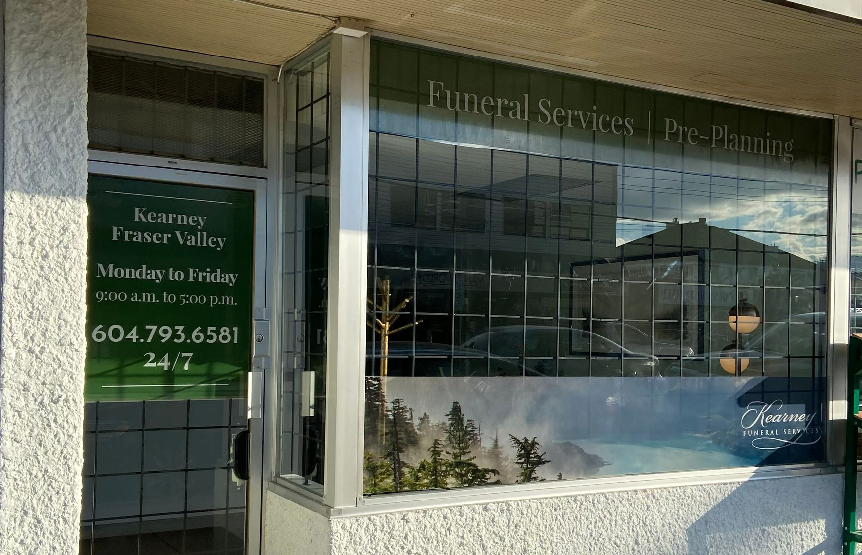 The storefront of Fraser Valley funeral home, featuring glass windows, business hours, and phone number 604-793-6581.