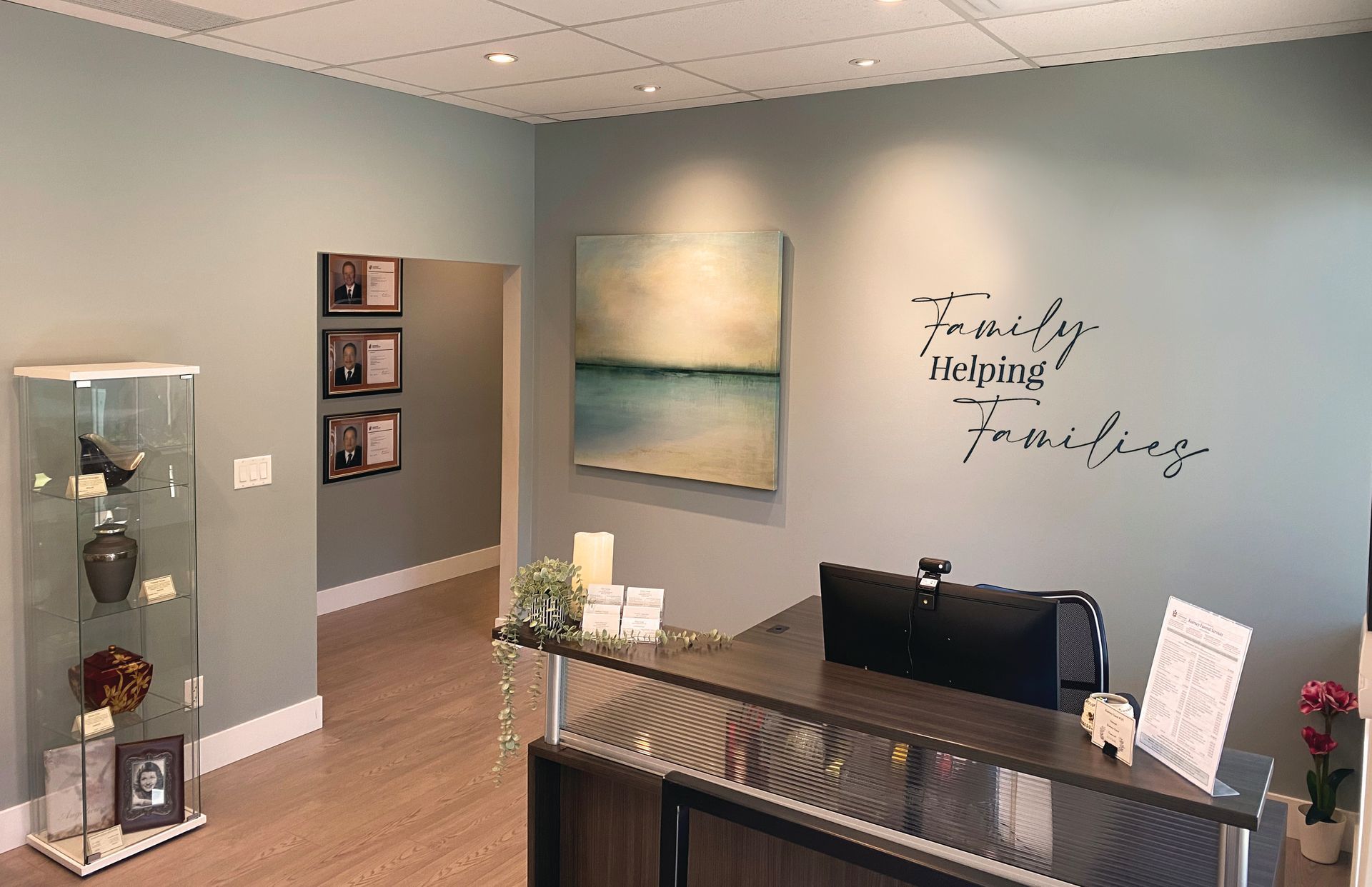 Reception desk in a waiting area with a wall sign reading 